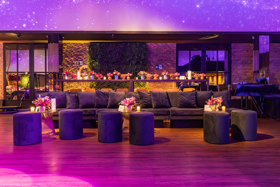 Luxurious event setting with plush seating, floral decor, and mood lighting in a modern lounge.